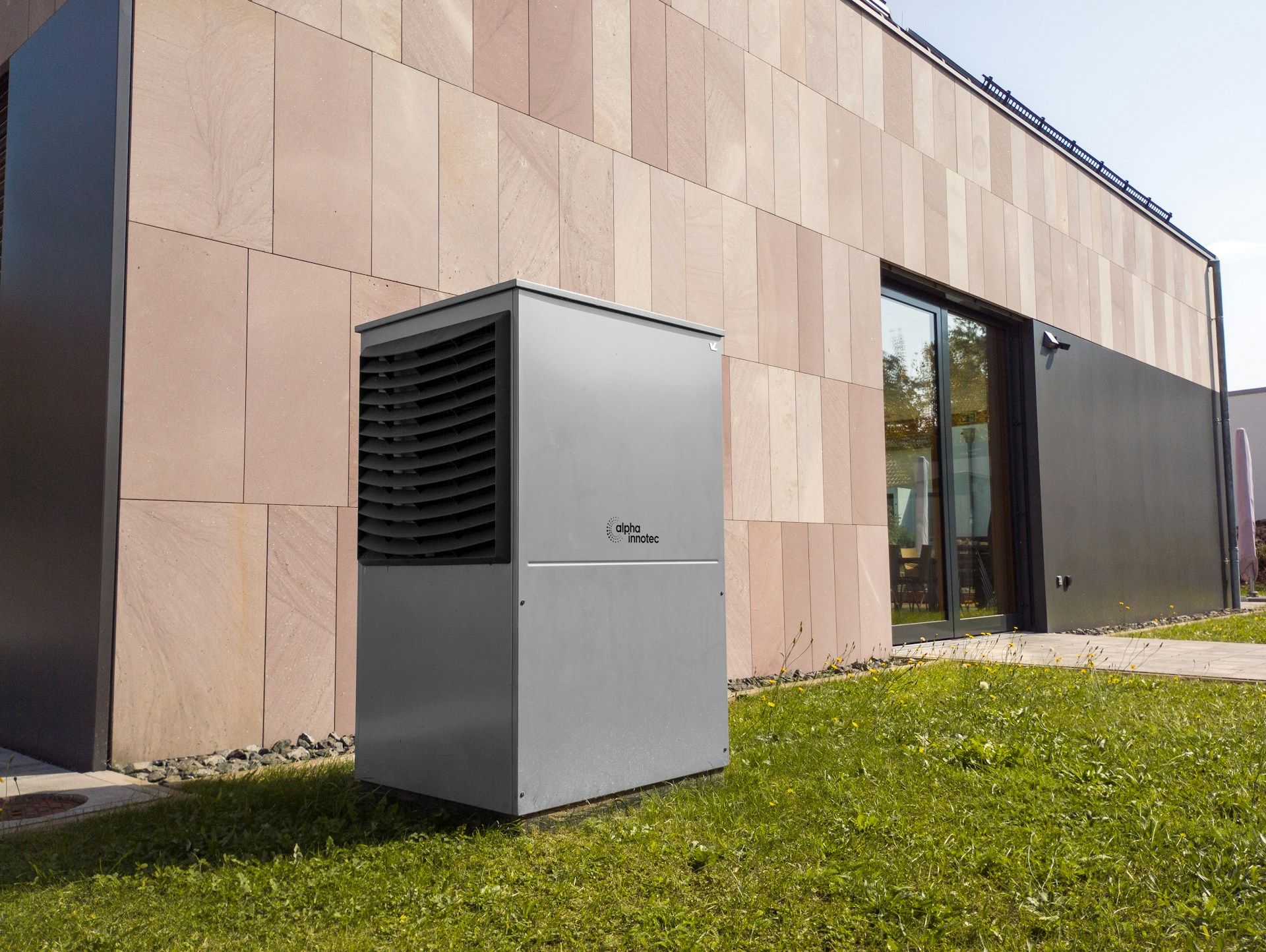 Warmtepomp buitenunit voor een moderne woning, foto alpha innotec via Unsplash